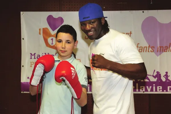 Hassan N'Dam avec un jeune boxeur ganté